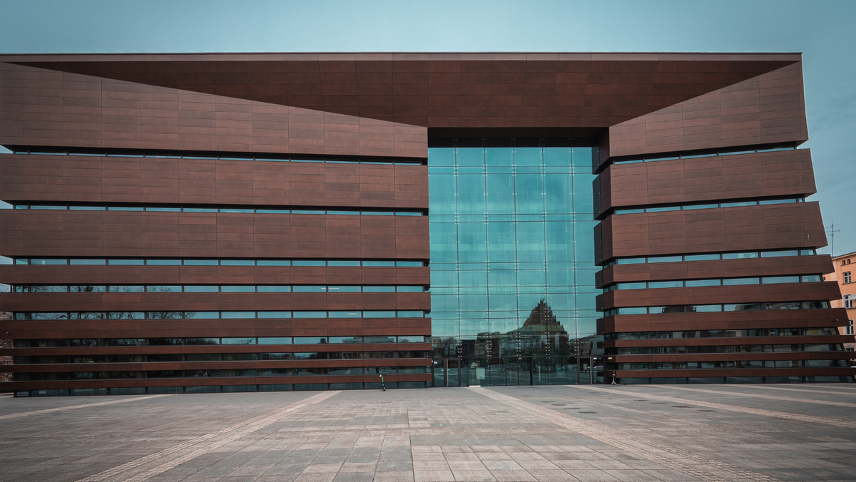 "Zdjęcie przedstawiające fasadę Narodowego Forum Muzyki we Wrocławiu, znanego z nowoczesnej architektury i doskonałej akustyki.